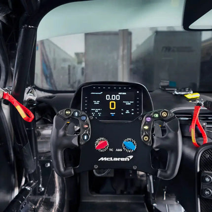 McLaren Artura Pro SC steering wheel in car with black and red colors.