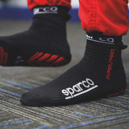 Detail of black racing socks with red logo on a white background